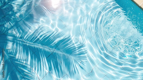 Surface of blue pool water with shadow from palm leaf, abstract summer fresh background photo