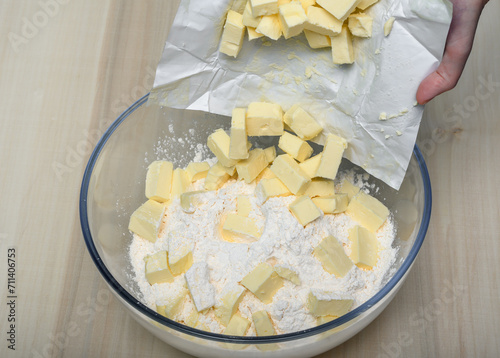 Wrzucać pokrojoną kostkę masła prosto z opakowania do miski z mąką
