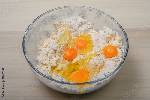 Rozbite jajka w misce z mąką składniki na kruche ciasto