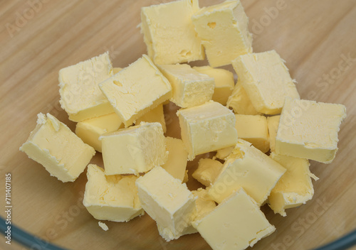 Żółte masło pokrojone w kostkę z misce z bliska 