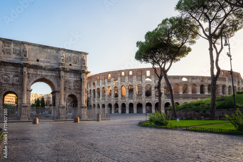 Amazing panoramic view of Arch of Constantine (Arco di Constantino) and Colosseum at beautiful warm light after sunrise, Rome, Italy.. photo