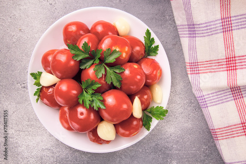 Image of red pizzcled canned tomatoes on a plate. Image of red canned tomatoes on a white plate