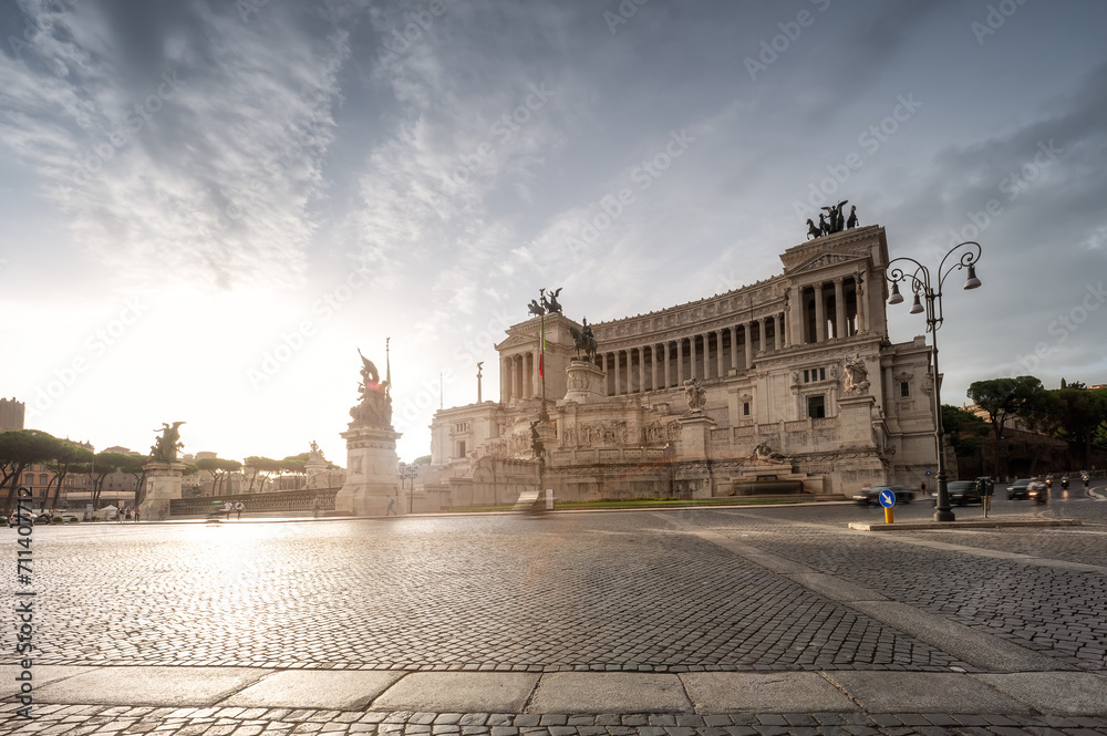 Street view of National Monument Victor Emmanuel II or Vittoriano at Piazza Venezia in the morning light at sunrise, Rome, Italy.