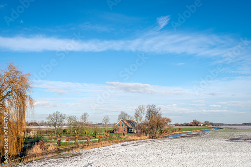 Picturesque Dutch landscape in the winter season. A thin layer of snow is on the fields and it is cold. The photo was taken in the Land van Heusden and Altena region in the province of North Brabant. © Ruud Morijn