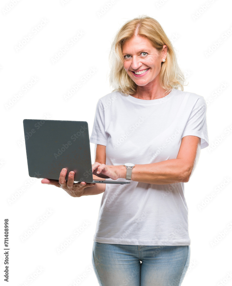 Middle age blonde woman using computer laptop over isolated background with a happy face standing and smiling with a confident smile showing teeth Middle age blonde woman using computer laptop over isolated background with a happy face standing and smiling with a confident smile showing teeth
