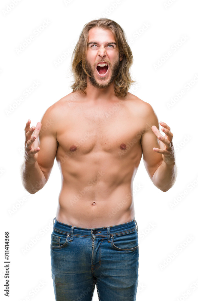 Fototapeta premium Young handsome shirtless man with long hair showing sexy body over isolated background crazy and mad shouting and yelling with aggressive expression and arms raised. Frustration concept.