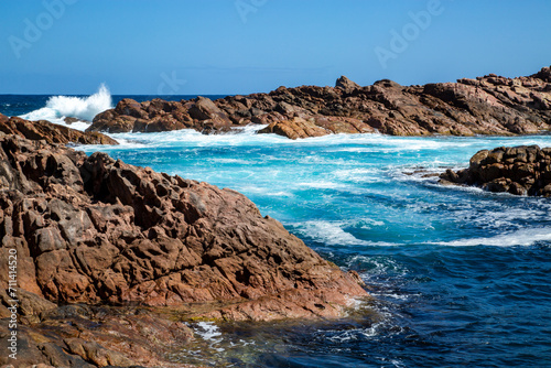 Ocean surging among rugged coastal rocks.