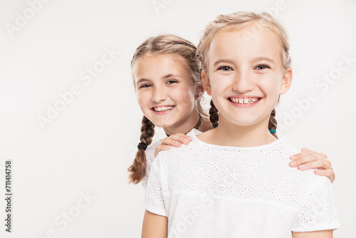 Studioportrait zwei Mädchen lachend mit Zahnlücken