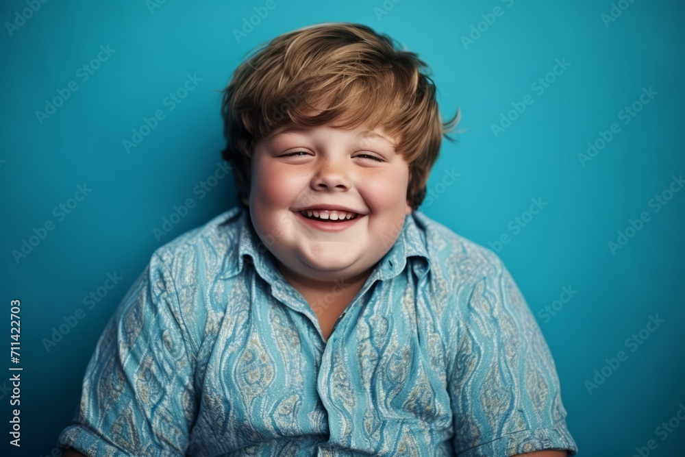 Joyful Young Boy Laughing Against a Teal Background Joyful Young Boy Laughing Against a Teal Background