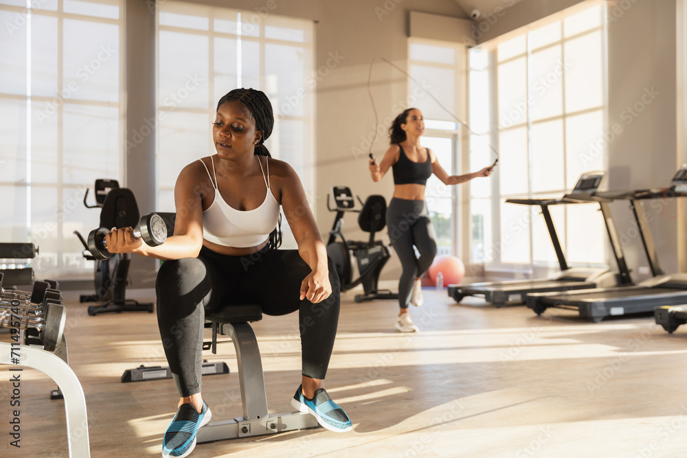 Healthy strong female African American plus-size holding dumbbells lifts weights exercise in gym. sport training weights fitness, Exercise to lose weight, take care of health.