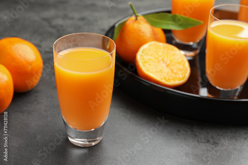 Delicious tangerine liqueur and fresh fruits on grey table, closeup