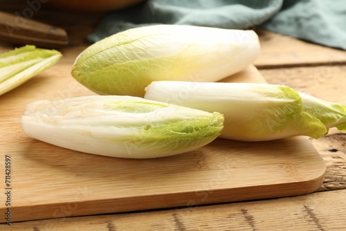 Fresh raw Belgian endives (chicory) on wooden table, closeup