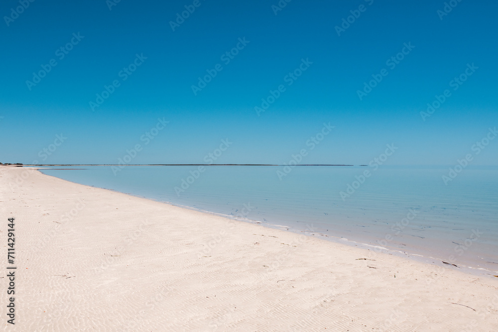 © Austockphoto - a peaceful beach with white sand and calm blue water © Austockphoto - a peaceful beach with white sand and calm blue water