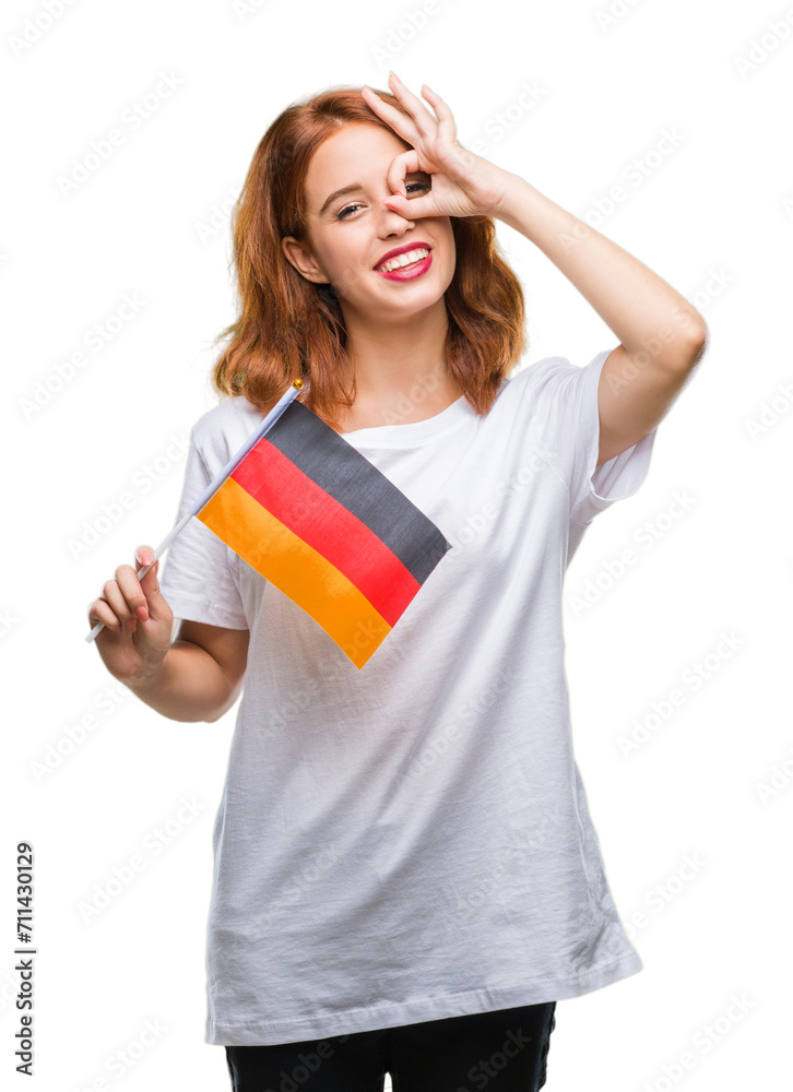 Young beautiful woman holding flag of germany over isolated background with happy face smiling doing ok sign with hand on eye looking through fingers Young beautiful woman holding flag of germany over isolated background with happy face smiling doing ok sign with hand on eye looking through fingers