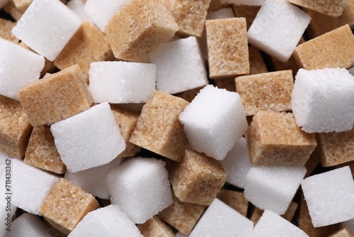 White and brown sugar cubes as background, top view