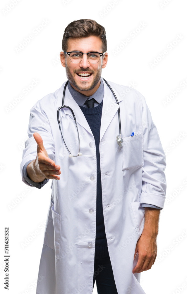 Young handsome doctor man over isolated background smiling friendly offering handshake as greeting and welcoming. Successful business.