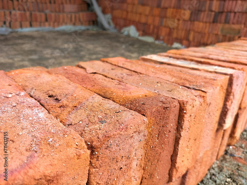 Selective focus. Red bricks from clay. Many clay is molded into bricks, after that it is laid out and dried in the yard in the sun before being burned to make it hard and dry. Pile of making batu bata