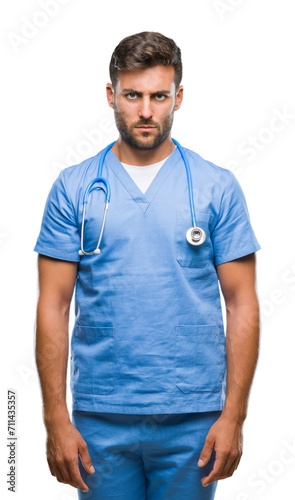 Young handsome doctor nurse man over isolated background skeptic and nervous, frowning upset because of problem. Negative person.