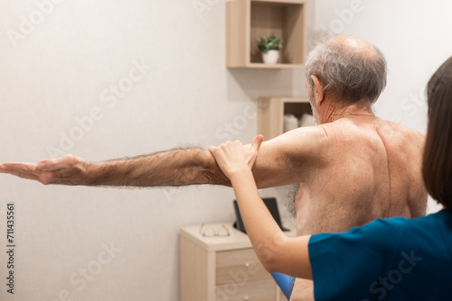 Physical therapy session with elderly male patient photo