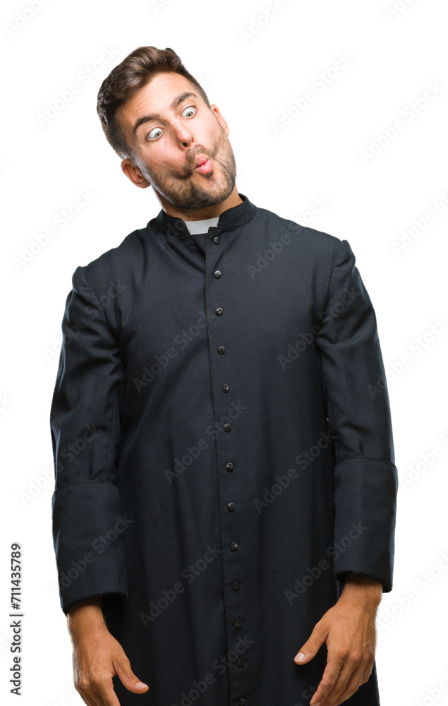Fototapeta premium Young catholic christian priest man over isolated background making fish face with lips, crazy and comical gesture. Funny expression.