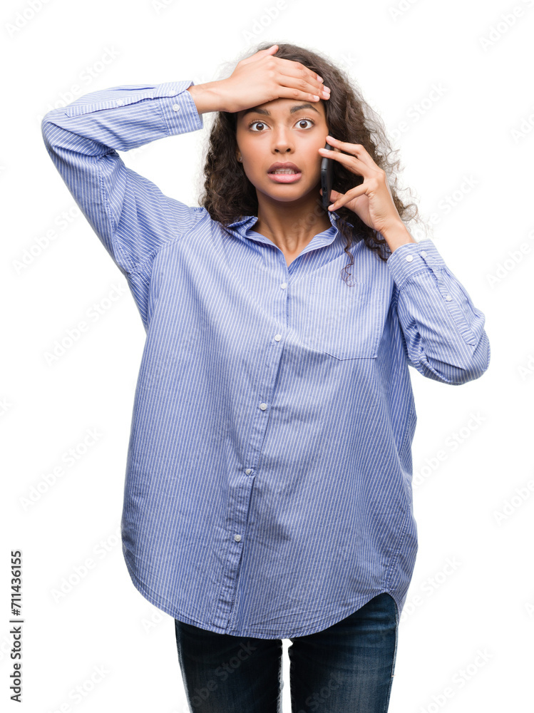 Young hispanic woman using smartphone stressed with hand on head, shocked with shame and surprise face, angry and frustrated. Fear and upset for mistake. Young hispanic woman using smartphone stressed with hand on head, shocked with shame and surprise face, angry and frustrated. Fear and upset for mistake.