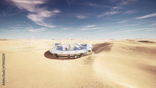 futuristic glass building in desert dunes photo