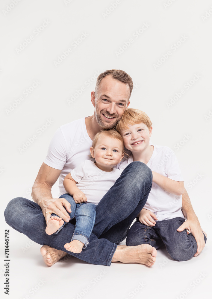Vater mit zwei Kindern Studioportrait in Jeans Vater mit zwei Kindern Studioportrait in Jeans