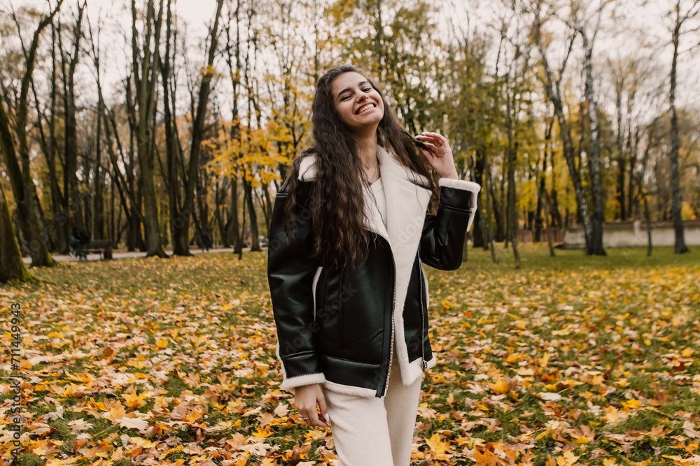 Attractive pretty woman walking outdoor, portrait of young lady in warm sunny autumn park season, fall, yellow orange red leaves, dressed leather wool fur jacket smiling having fun
Attractive pretty woman walking outdoor, portrait of young lady in warm sunny autumn park season, fall, yellow orange red leaves, dressed leather wool fur jacket smiling having fun