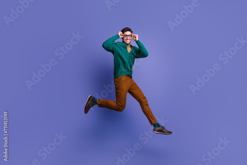 Photo of successful positive man wear trendy clothes hurrying store mall buy eyeglasses optics isolated on violet color background