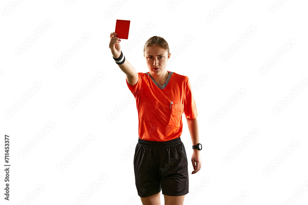Serious young woman, football referee in uniform showing red card as dismissal symbol against white studio background. Concept of sport, competition, match, profession, control Serious young woman, football referee in uniform showing red card as dismissal symbol against white studio background. Concept of sport, competition, match, profession, control