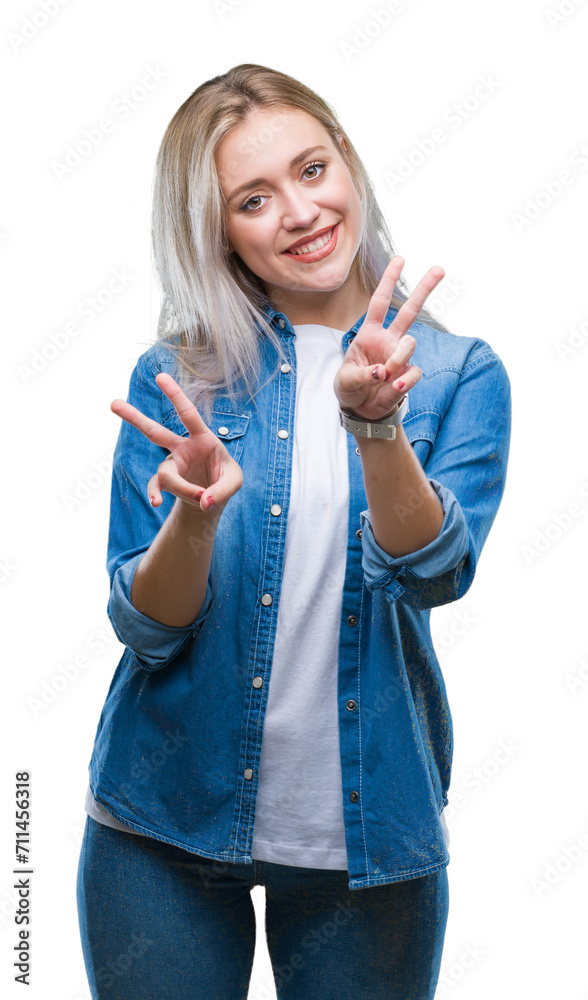 Obraz premium Young blonde woman over isolated background smiling looking to the camera showing fingers doing victory sign. Number two.