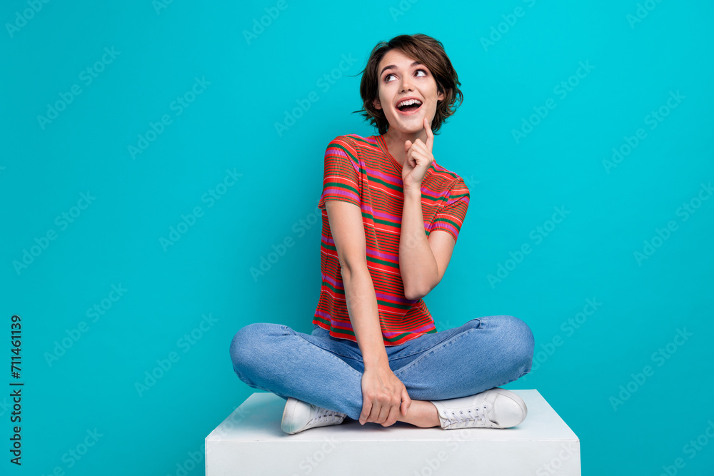 Photo of lovely dreamy cute girl wear trendy clothes hand touch chin look up empty space news offer isolated on cyan color background Photo of lovely dreamy cute girl wear trendy clothes hand touch chin look up empty space news offer isolated on cyan color background