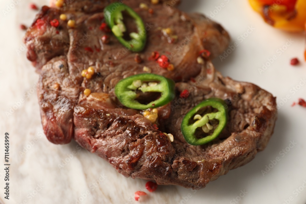 Delicious fried beef meat with chili pepper on marble board, closeup Delicious fried beef meat with chili pepper on marble board, closeup