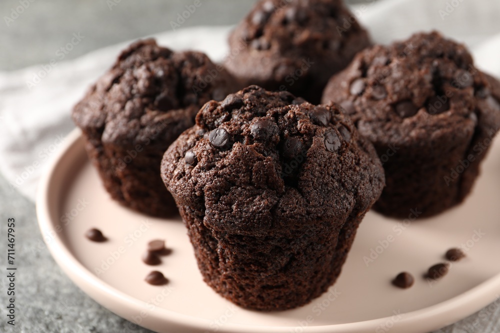 Delicious fresh chocolate muffins on grey table, closeup Delicious fresh chocolate muffins on grey table, closeup