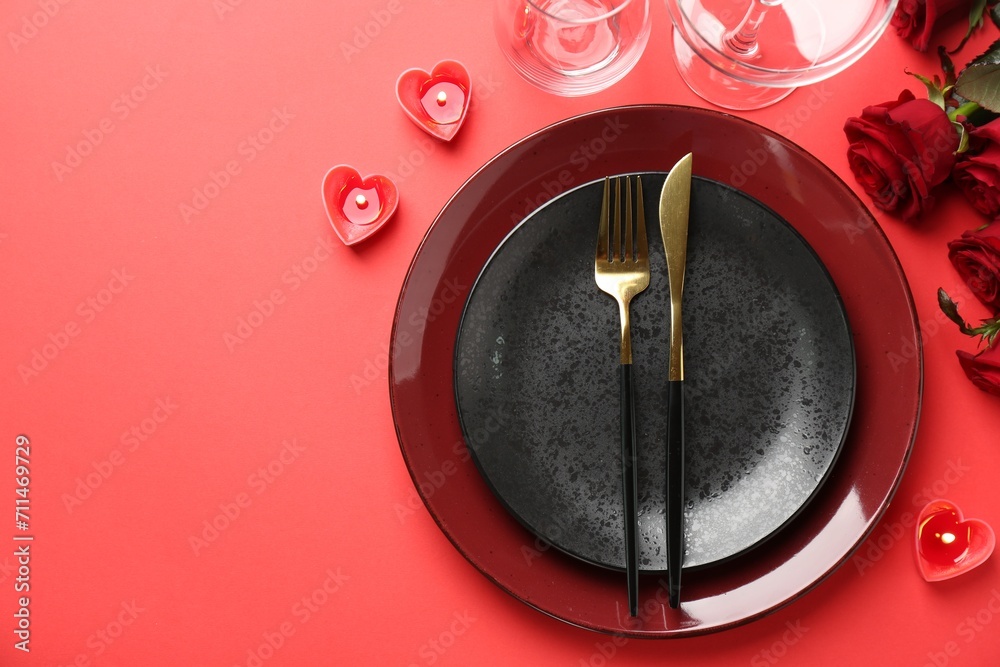 Place setting with heart shaped candles and bouquet of roses for romantic dinner on red table, flat lay. Space for text Place setting with heart shaped candles and bouquet of roses for romantic dinner on red table, flat lay. Space for text