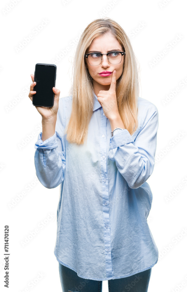 Young beautiful blonde business woman showing screen of smartphone over isolated background serious face thinking about question, very confused idea Young beautiful blonde business woman showing screen of smartphone over isolated background serious face thinking about question, very confused idea