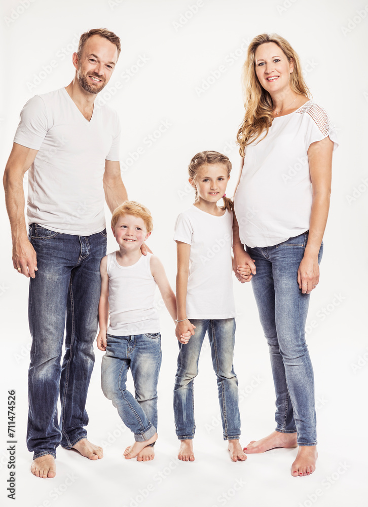 Studioportrait schwangere Frau mit Familie mit zwei Kindern barfuss in Jeans, lächelnd in die Kamera Studioportrait schwangere Frau mit Familie mit zwei Kindern barfuss in Jeans, lächelnd in die Kamera