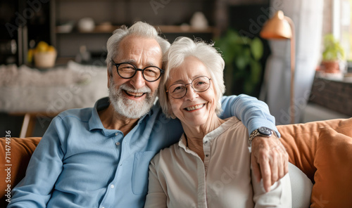 Portrait of a happy senior couple relaxing together on the sofa at home. Elderly couple enjoying free time together. Mature couple laughing and cuddling. 