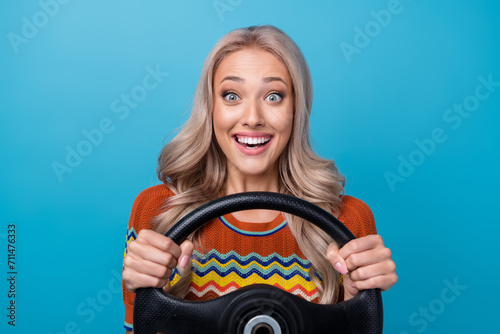 Photo of sweet impressed girl dressed print shirt riding automobile isolated blue color background