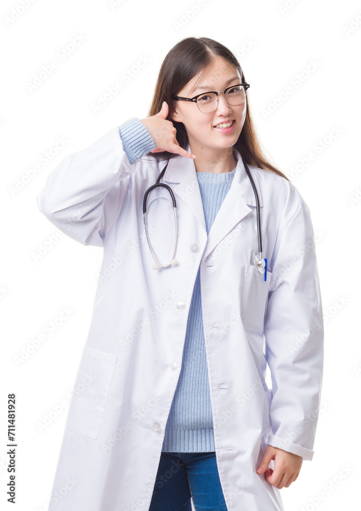 Young Chinese doctor woman over isolated background smiling doing phone gesture with hand and fingers like talking on the telephone. Communicating concepts. Young Chinese doctor woman over isolated background smiling doing phone gesture with hand and fingers like talking on the telephone. Communicating concepts.