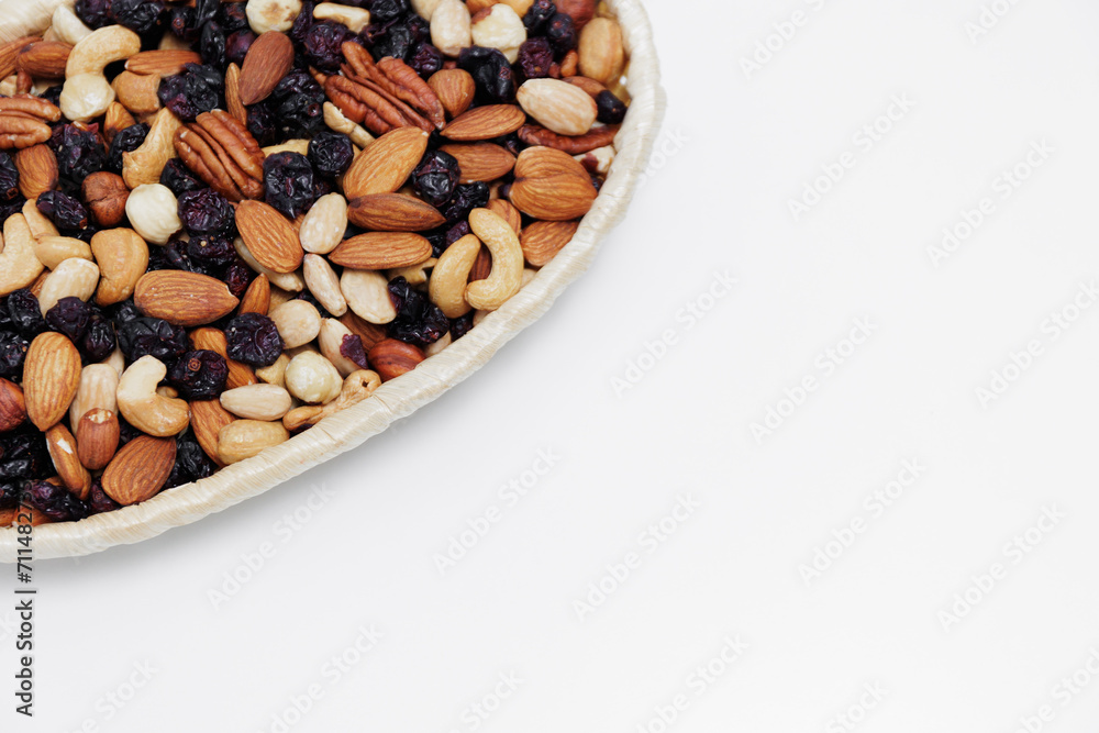 close up of various nuts in wooden bowl over white table close up of various nuts in wooden bowl over white table