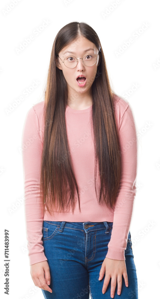 Obraz premium Young Chinese woman over isolated background wearing glasses afraid and shocked with surprise expression, fear and excited face.