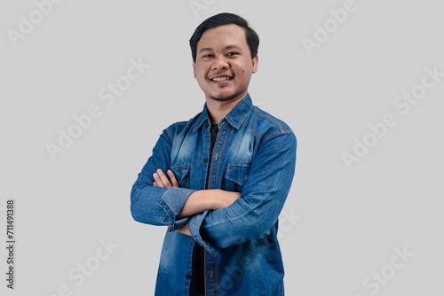 Young Asian Man folded arms looking at camera with happy face expression on isolated background