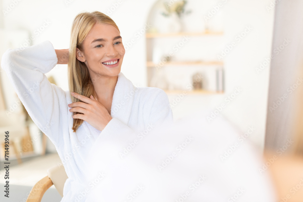 blonde lady touching long hair caring for herself in bathroom blonde lady touching long hair caring for herself in bathroom