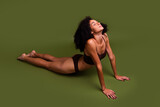 No retouch photo of charming sporty girl stretching on floor yoga pilates aerobics isolated over khaki color background