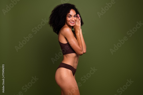 Studio no retouch profile photo of shiny cheerful lady dressed lingerie enjoying sporty body empty space isolated green color background