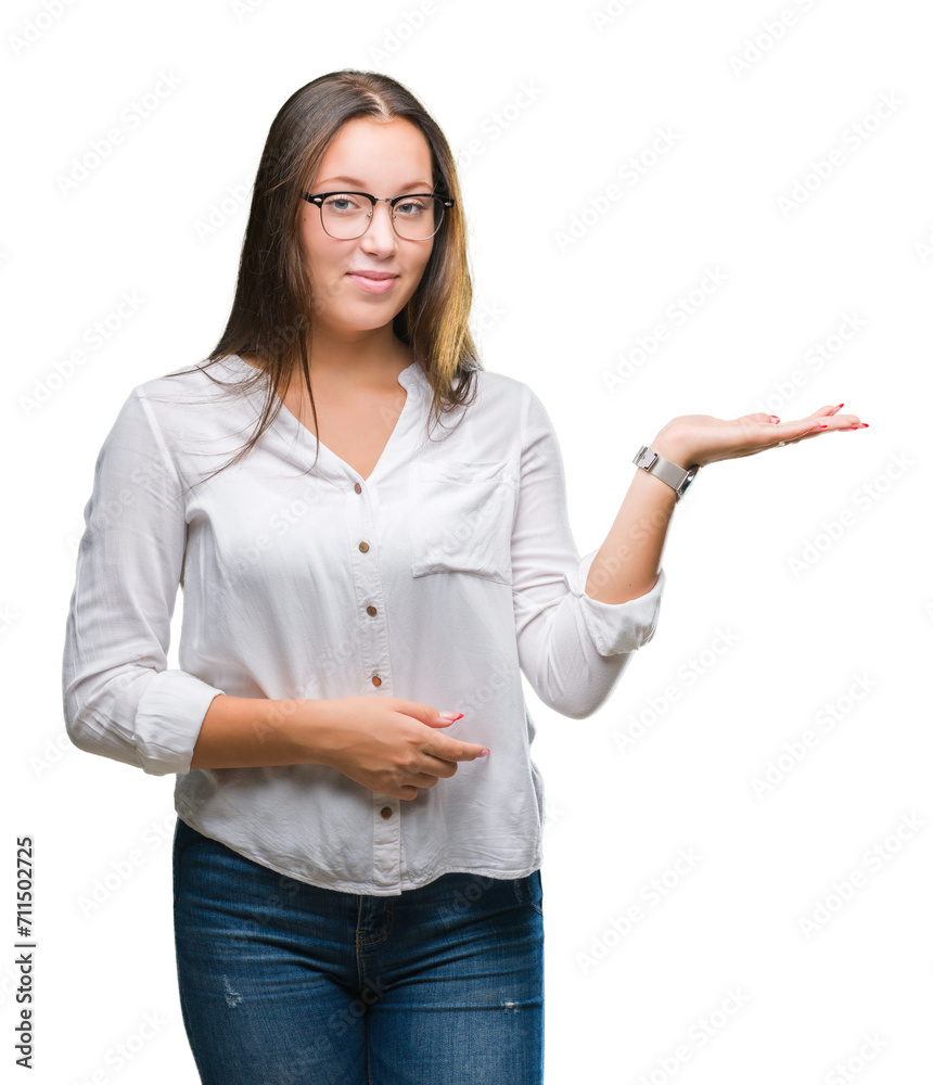 Young caucasian beautiful business woman wearing glasses over isolated background smiling cheerful presenting and pointing with palm of hand looking at the camera. Young caucasian beautiful business woman wearing glasses over isolated background smiling cheerful presenting and pointing with palm of hand looking at the camera.
