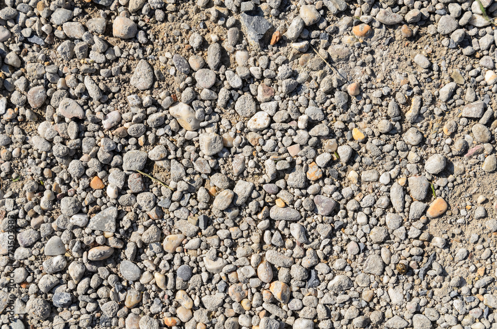 Abstract background with crushed gravel and small little grey rocks and stones, close-up view from directly above