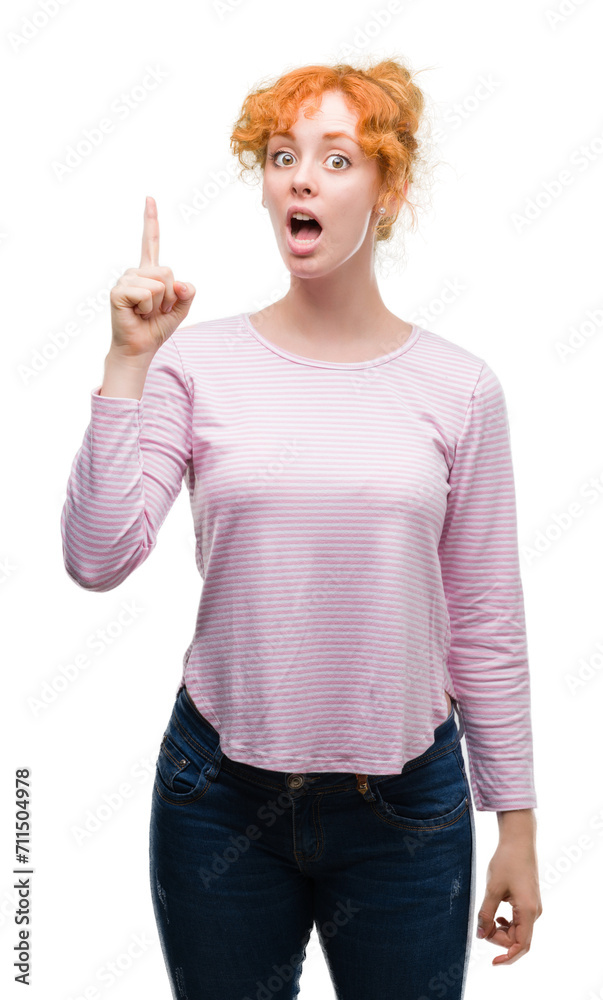 Young redhead woman pointing finger up with successful idea. Exited and happy. Number one. Young redhead woman pointing finger up with successful idea. Exited and happy. Number one.