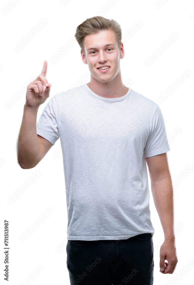 Young handsome blond man surprised with an idea or question pointing finger with happy face, number one Young handsome blond man surprised with an idea or question pointing finger with happy face, number one
